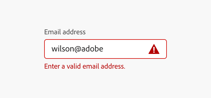 Example of a well-designed error state on an "Email address" field containing "wilson@adobe," with a red outline, a warning triangle icon inside the field, and red helper text below reading "Enter a valid email address."